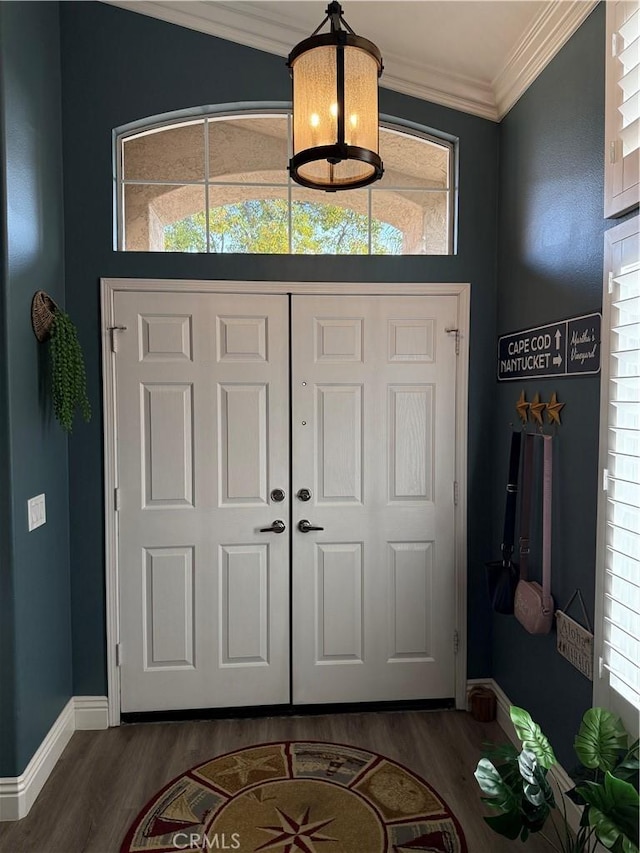 entrance foyer featuring a healthy amount of sunlight, baseboards, crown molding, and wood finished floors