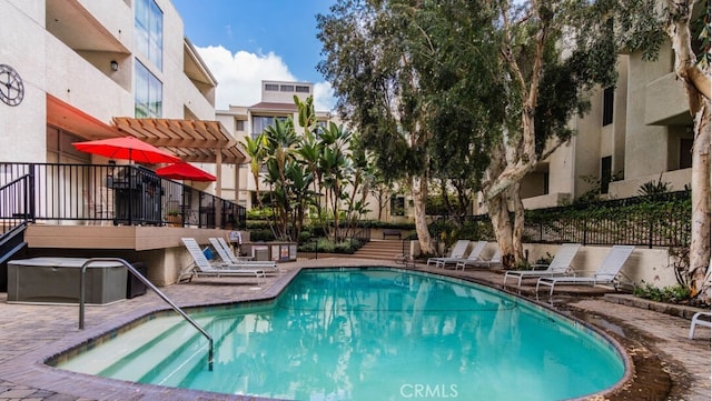 community pool with a patio area, fence, and a pergola