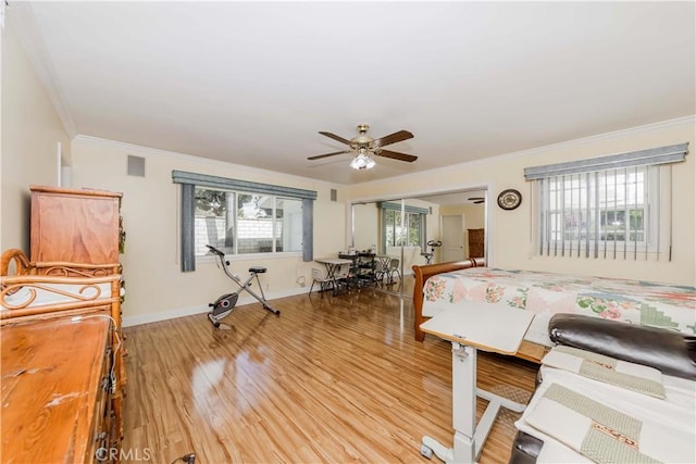 bedroom featuring ornamental molding, light wood finished floors, and multiple windows