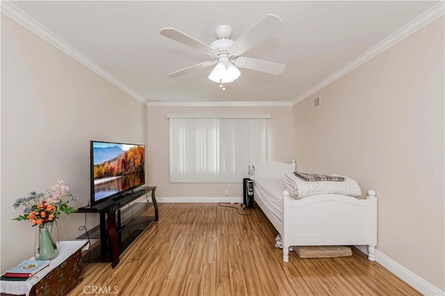 bedroom featuring light wood finished floors, baseboards, a ceiling fan, and ornamental molding