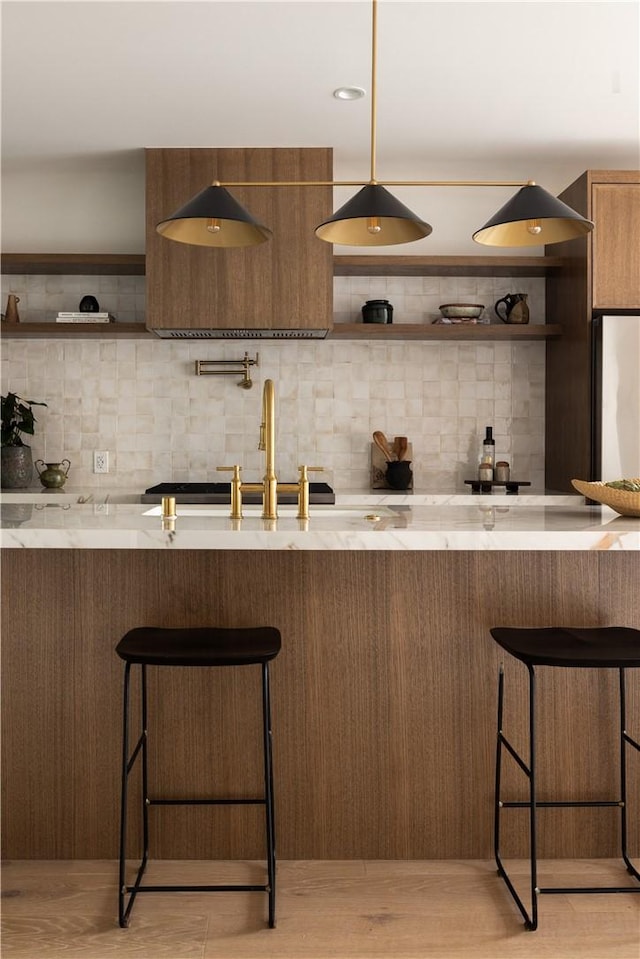 kitchen with tasteful backsplash, open shelves, and a sink