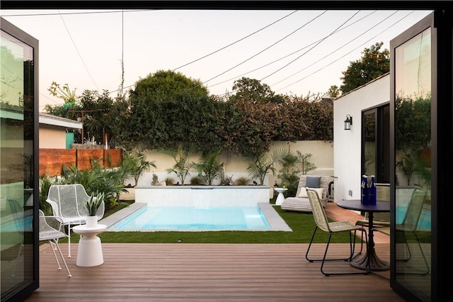 view of swimming pool featuring a fenced backyard, a deck, and a fenced in pool