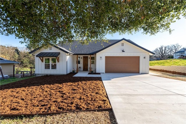 modern farmhouse featuring board and batten siding, concrete driveway, and an attached garage