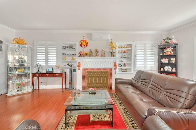 living area featuring plenty of natural light, a wall mounted air conditioner, wood finished floors, and a brick fireplace