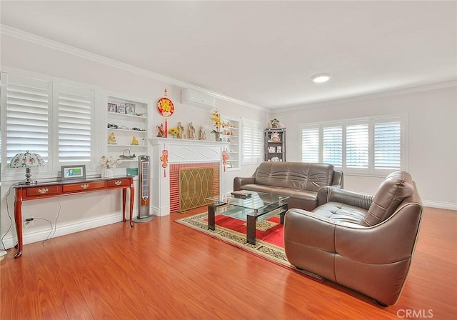 living area featuring a wall unit AC, crown molding, built in features, and wood finished floors