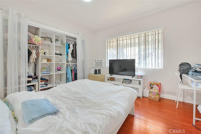 bedroom featuring a closet, baseboards, and wood finished floors