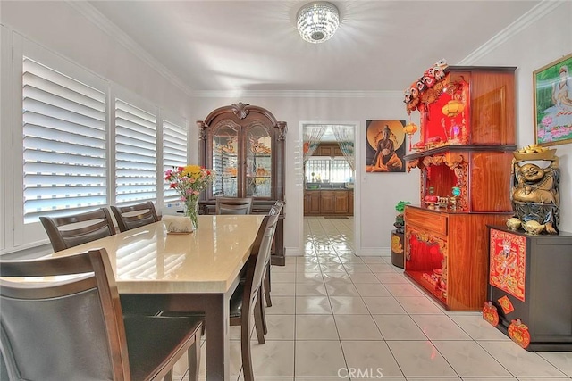 dining room with baseboards, crown molding, and light tile patterned flooring