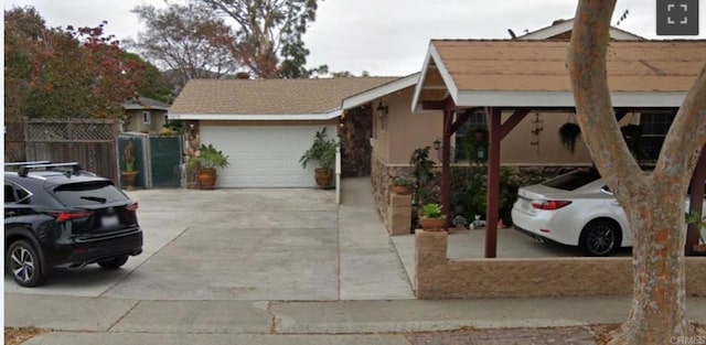 view of front of house with concrete driveway, an attached garage, and fence