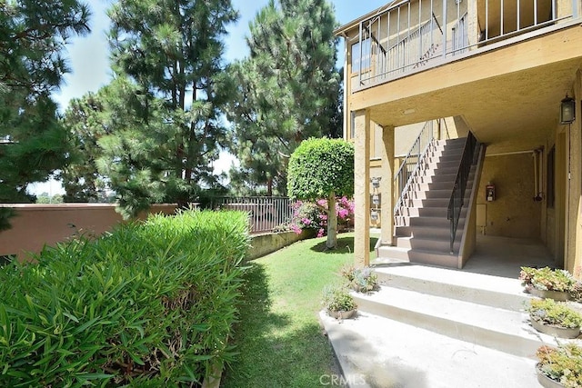 view of yard with fence and stairs