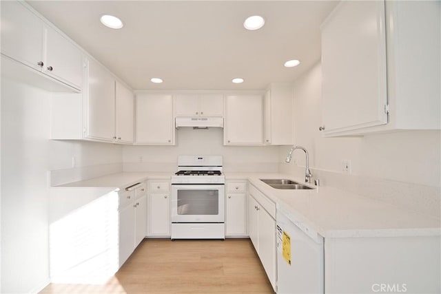 kitchen with white appliances, white cabinets, a sink, and under cabinet range hood