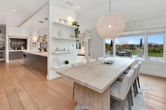 dining space with light wood finished floors, baseboards, visible vents, and recessed lighting