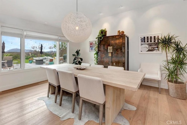 dining space featuring baseboards and light wood finished floors