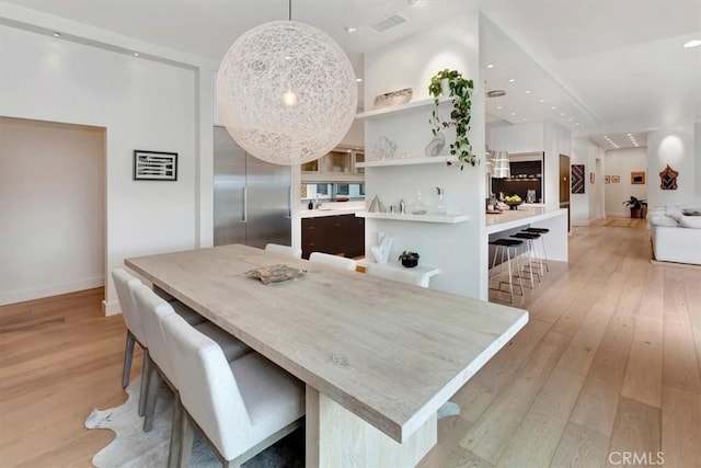 dining space with recessed lighting, light wood-style flooring, and baseboards