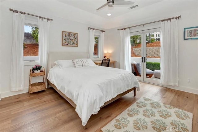 bedroom with access to outside, multiple windows, visible vents, and light wood-style floors