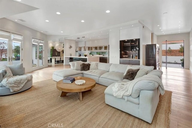 living area with light wood finished floors, a wealth of natural light, and recessed lighting