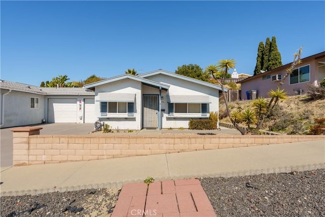 view of front facade with a garage, driveway, and stucco siding