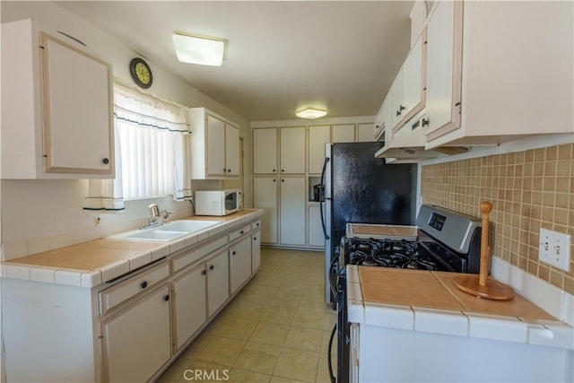 3648 Mira Pacific Dr, Oceanside, CA 92056 - kitchen with light tile patterned floors, white microwave, a sink, backsplash, and gas stove