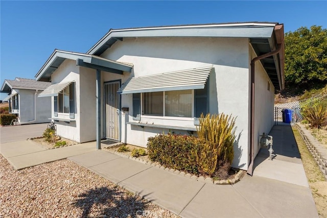 view of front facade featuring fence and stucco siding