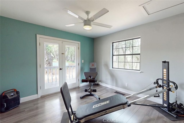 exercise area featuring a healthy amount of sunlight, baseboards, wood finished floors, and french doors