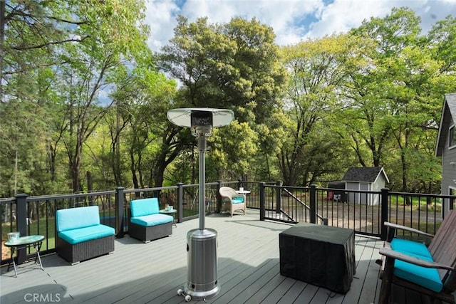 wooden terrace with a storage unit and an outdoor structure