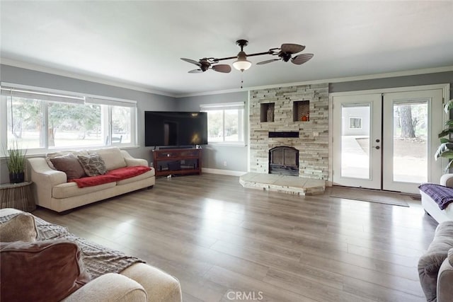 living area featuring crown molding, french doors, wood finished floors, and a healthy amount of sunlight