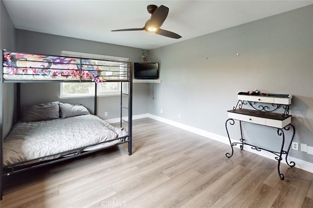 bedroom featuring ceiling fan, baseboards, and wood finished floors