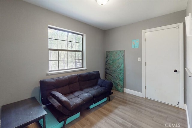 living area with baseboards and wood finished floors