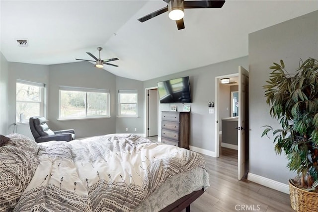 bedroom featuring vaulted ceiling, multiple windows, visible vents, and light wood-style floors