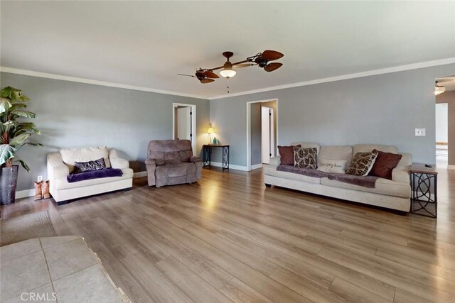 living area with a ceiling fan, baseboards, wood finished floors, and ornamental molding