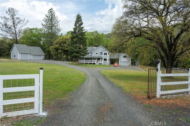 exterior space featuring an outbuilding, a detached garage, fence, and a front yard