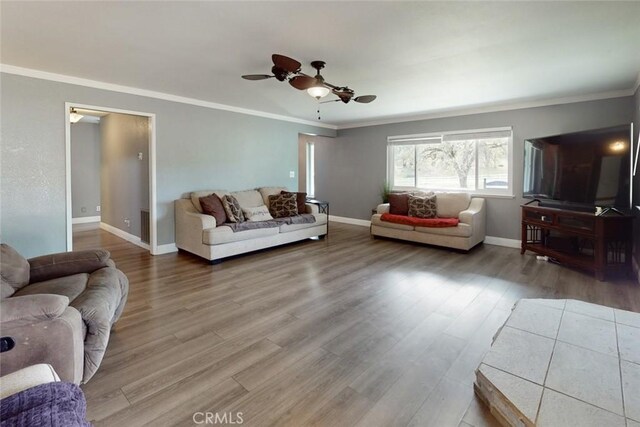 living room featuring ornamental molding, wood finished floors, and baseboards