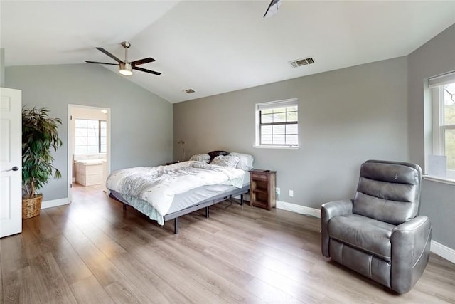 bedroom with lofted ceiling, visible vents, baseboards, and wood finished floors