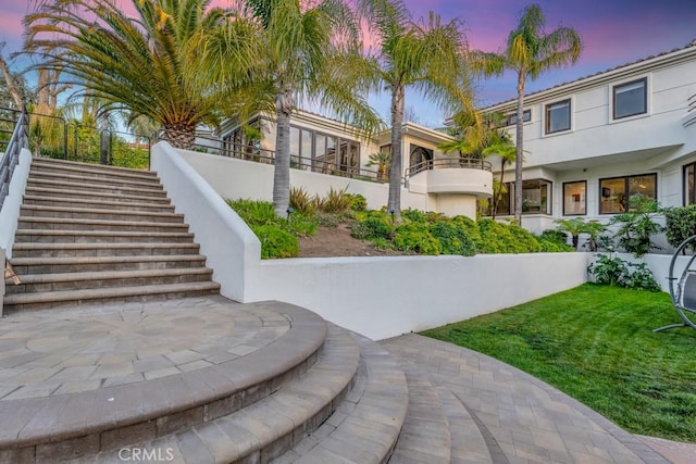 exterior space with stairway and a lawn