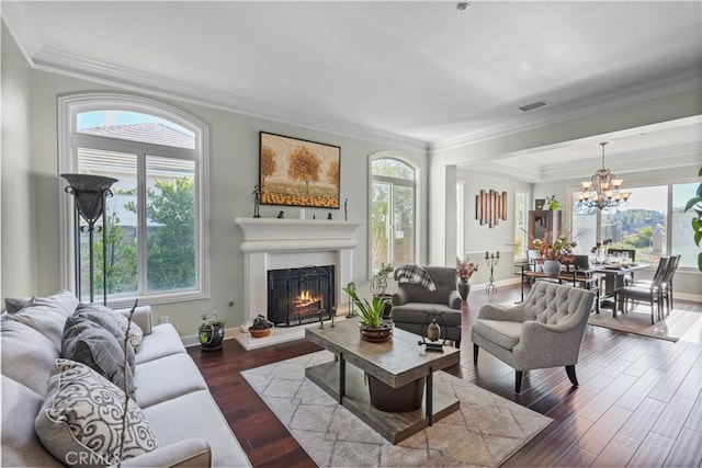 living room with baseboards, visible vents, a lit fireplace, dark wood-type flooring, and crown molding