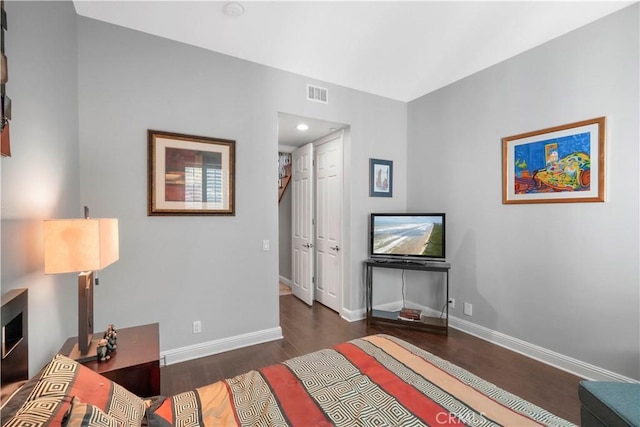 bedroom featuring wood finished floors, visible vents, baseboards, recessed lighting, and a closet