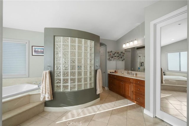 full bathroom with tile patterned floors, vanity, a garden tub, and vaulted ceiling