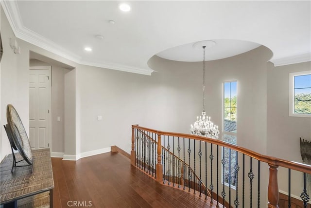 hallway featuring crown molding, baseboards, a chandelier, an upstairs landing, and wood finished floors