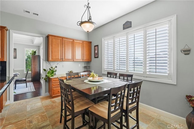 dining room with visible vents, stone finish flooring, and baseboards