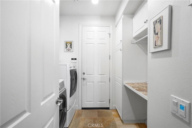 12364 Palmer Dr, Moorpark, CA 93021 - clothes washing area featuring separate washer and dryer, stone finish flooring, and cabinet space