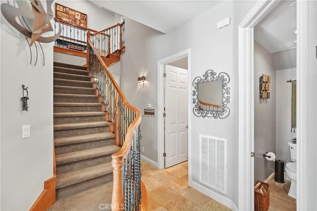 stairway with visible vents and baseboards