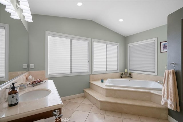 bathroom with tile patterned floors, a garden tub, lofted ceiling, baseboards, and vanity