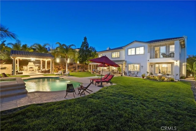 back of house featuring a patio, a balcony, a yard, an outdoor pool, and a pergola