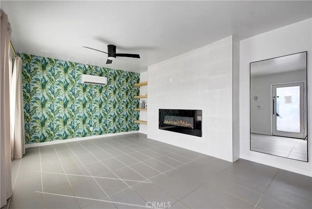 unfurnished living room featuring wallpapered walls, baseboards, a ceiling fan, a glass covered fireplace, and tile patterned floors