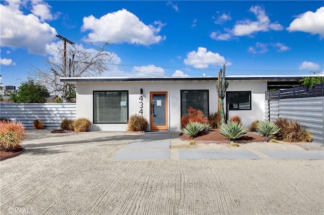 view of front facade featuring fence and stucco siding