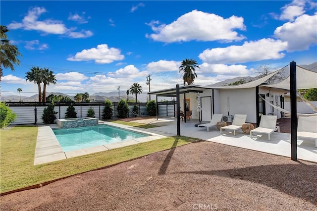 view of swimming pool featuring a yard, a pool with connected hot tub, a fenced backyard, and a patio