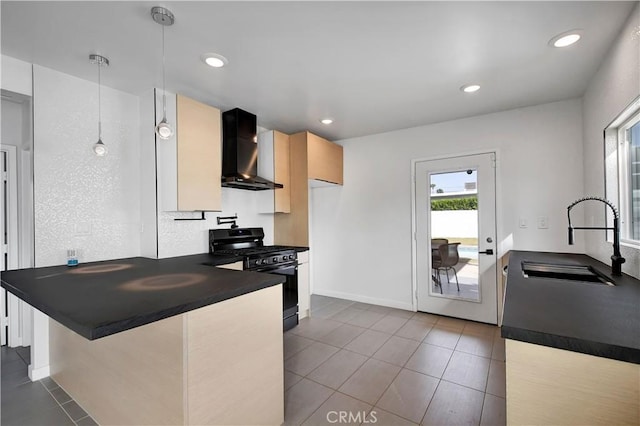 kitchen featuring dark countertops, a sink, black range with gas cooktop, a peninsula, and wall chimney exhaust hood