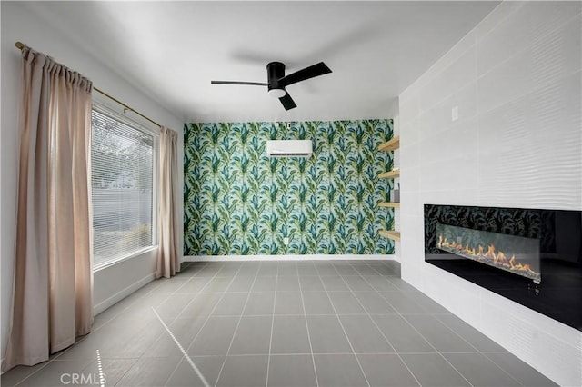 tiled living room featuring baseboards, ceiling fan, a glass covered fireplace, and wallpapered walls