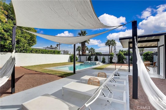 exterior space featuring a patio area, a fenced backyard, and a pool with connected hot tub