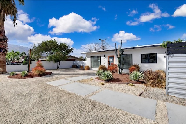 view of front of home featuring fence and stucco siding