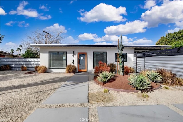 view of front facade featuring fence and stucco siding